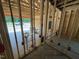 Exposed framing showing plumbing and wiring of a home under construction, with a glimpse of the garage at 4024 N Nc 581 Hwy, Kenly, NC 27542