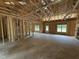 Unfinished living room featuring exposed framing, multiple windows, and a door for plenty of natural light at 4024 N Nc 581 Hwy, Kenly, NC 27542