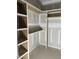 Interior of walk-in closet with custom wood shelving and ample storage space, offering organization and style at 4035 King Charles Rd, Durham, NC 27707