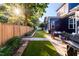 Beautiful backyard with manicured lawn, fenced perimeter, patio furniture, and lush green landscaping at 405 Culvert St, Apex, NC 27502