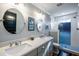 Modern bathroom featuring double sinks, stylish mirrors, and a glass-enclosed shower with attractive tile at 405 Culvert St, Apex, NC 27502
