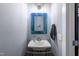 A clean, gray bathroom with a pedestal sink, an ornate mirror, and modern fixtures at 405 Culvert St, Apex, NC 27502