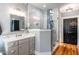 Modern bathroom featuring a shower with glass doors, a vanity with quartz countertops, and hardwood floors at 405 Culvert St, Apex, NC 27502