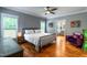 Spacious bedroom with hardwood floors, a ceiling fan, natural lighting, and access to an en-suite bathroom at 405 Culvert St, Apex, NC 27502