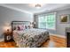 Well-lit bedroom featuring a large window, a bed with decorative pillows, and tasteful decor at 405 Culvert St, Apex, NC 27502
