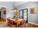Well-lit dining room area featuring a wooden table with seating and direct access to a backyard patio at 405 Culvert St, Apex, NC 27502