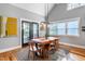 A dining room featuring a wooden table with seating, hardwood floors, modern fixtures, and a view of the backyard at 405 Culvert St, Apex, NC 27502