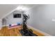 A compact exercise room with an elliptical machine, TV, and hardwood floors at 405 Culvert St, Apex, NC 27502