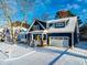 Inviting blue two-story home in the snow with white trim, a yellow front door, and an attached garage at 405 Culvert St, Apex, NC 27502