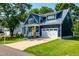 Charming blue two-story home featuring a yellow front door, manicured lawn and white trim at 405 Culvert St, Apex, NC 27502