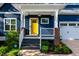 Close up of the front porch and yellow door of a charming two-story blue home at 405 Culvert St, Apex, NC 27502