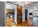 Hallway with wood floors, sliding barn door, and view into living space at 405 Culvert St, Apex, NC 27502