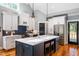 Modern kitchen with custom white cabinets, large island, stainless steel appliances, and hardwood floors at 405 Culvert St, Apex, NC 27502