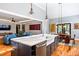 Bright kitchen featuring an island with a sink, quartz countertops, stainless steel appliances, and hardwood floors at 405 Culvert St, Apex, NC 27502
