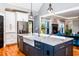 Bright kitchen featuring an island with a sink, quartz countertops, stainless steel appliances, and hardwood floors at 405 Culvert St, Apex, NC 27502