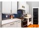 Updated kitchen features stainless appliances, modern backsplash and fixtures, and white cabinets at 405 Culvert St, Apex, NC 27502