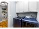 Bright laundry room with upper cabinets and modern blue front load washer and dryer at 405 Culvert St, Apex, NC 27502