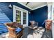 Cozy covered porch with wicker furniture and a blue painted exterior at 405 Culvert St, Apex, NC 27502