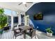 Comfortable screened porch with seating, ceiling fan, mounted TV, and blue wood paneling for relaxing and entertaining at 405 Culvert St, Apex, NC 27502