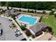 An aerial view of a community pool with lounge chairs, umbrellas, and a parking lot for residents at 427 Cedar Pond Ct, Knightdale, NC 27545