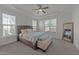 Large bedroom with trey ceilings, a ceiling fan, large windows and a padded bench at the foot of the bed at 427 Cedar Pond Ct, Knightdale, NC 27545