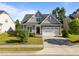 Charming gray shake shingle home with lush landscaping, well-manicured lawn and a two-car garage at 427 Cedar Pond Ct, Knightdale, NC 27545