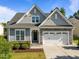 Charming home showcasing a stone and gray shake facade, complemented by a well-manicured lawn and a two-car garage at 427 Cedar Pond Ct, Knightdale, NC 27545