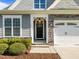 Charming home exterior with stone accents, a stylish front door, and manicured landscaping at 427 Cedar Pond Ct, Knightdale, NC 27545