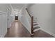 Inviting hallway with dark wood floors, wainscoting, leading to front door and stairs to second floor at 427 Cedar Pond Ct, Knightdale, NC 27545