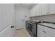 Functional laundry room with modern washer and dryer, storage cabinets, and a utility sink at 427 Cedar Pond Ct, Knightdale, NC 27545