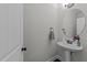 A powder room with a pedestal sink, a decorative mirror, and attractive fixtures with neutral gray paint at 427 Cedar Pond Ct, Knightdale, NC 27545