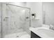 Modern bathroom featuring marble tiled shower with glass door, white vanity, and sleek fixtures at 513 Basin Hill Dr, Wake Forest, NC 27587