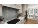 Close-up of the kitchen showcasing the cooktop, tile backsplash, stainless steel appliances, and adjacent dining area at 528 Folk Song Way, Wendell, NC 27591