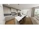 Modern kitchen with white cabinetry, stainless steel appliances, an island with seating, and eat-in dining area at 528 Folk Song Way, Wendell, NC 27591
