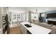 Open-concept kitchen flowing into living room and dining area with stainless steel appliances and island at 528 Folk Song Way, Wendell, NC 27591