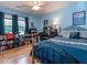 Stylish blue bedroom with dark wood accents, showcasing a cozy bed and a functional workspace at 5536 Centipede Trl, Raleigh, NC 27610