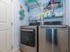 Efficient laundry room featuring stainless steel washer and dryer, with storage shelving at 5536 Centipede Trl, Raleigh, NC 27610