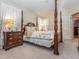 Bedroom features a wooden four-poster bed with decorative floral bedding, furniture, and neutral walls at 5536 Centipede Trl, Raleigh, NC 27610