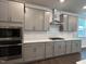Modern kitchen with subway tile backsplash, stainless steel appliances, and gray cabinetry at 5649 Cayden Cove Dr, Wendell, NC 27591