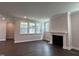 Bright living room features dark wood floors, fireplace, and large windows at 5649 Cayden Cove Dr, Wendell, NC 27591