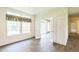 Bright living room features wood-look flooring, large windows, and open doorway to sunroom at 589 Atkinson Mill Rd, Selma, NC 27576