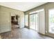Bright sunroom with natural wood paneled walls and view of kitchen through doorway at 589 Atkinson Mill Rd, Selma, NC 27576