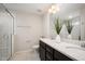 Modern bathroom with a double sink vanity, quartz countertop, and a luxurious glass-enclosed shower at 6107 Kayton St, Raleigh, NC 27616