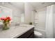 Bathroom with shower and tub combo, white countertop, and dark brown cabinets at 6107 Kayton St, Raleigh, NC 27616
