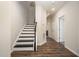 Bright entryway featuring a staircase with dark wood handrail and luxury vinyl flooring, leading to the upper level at 6107 Kayton St, Raleigh, NC 27616