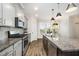 A modern kitchen featuring granite countertops, stainless steel appliances, and stylish pendant lighting at 6107 Kayton St, Raleigh, NC 27616
