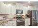 Close-up of kitchen with granite counters, white cabinets, and stainless steel oven and microwave at 6301 Pesta Ct, Raleigh, NC 27612