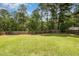 Lush backyard with a full green lawn and a wood fence border and mature trees at 642 Pinevalley Ln, Sanford, NC 27332