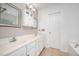 Well-lit bathroom featuring double sinks, white cabinets, and decorative mirrors above each sink at 642 Pinevalley Ln, Sanford, NC 27332