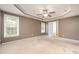 Empty bedroom showcasing the trey ceiling, two large windows, and a doorway to an adjacent room at 642 Pinevalley Ln, Sanford, NC 27332